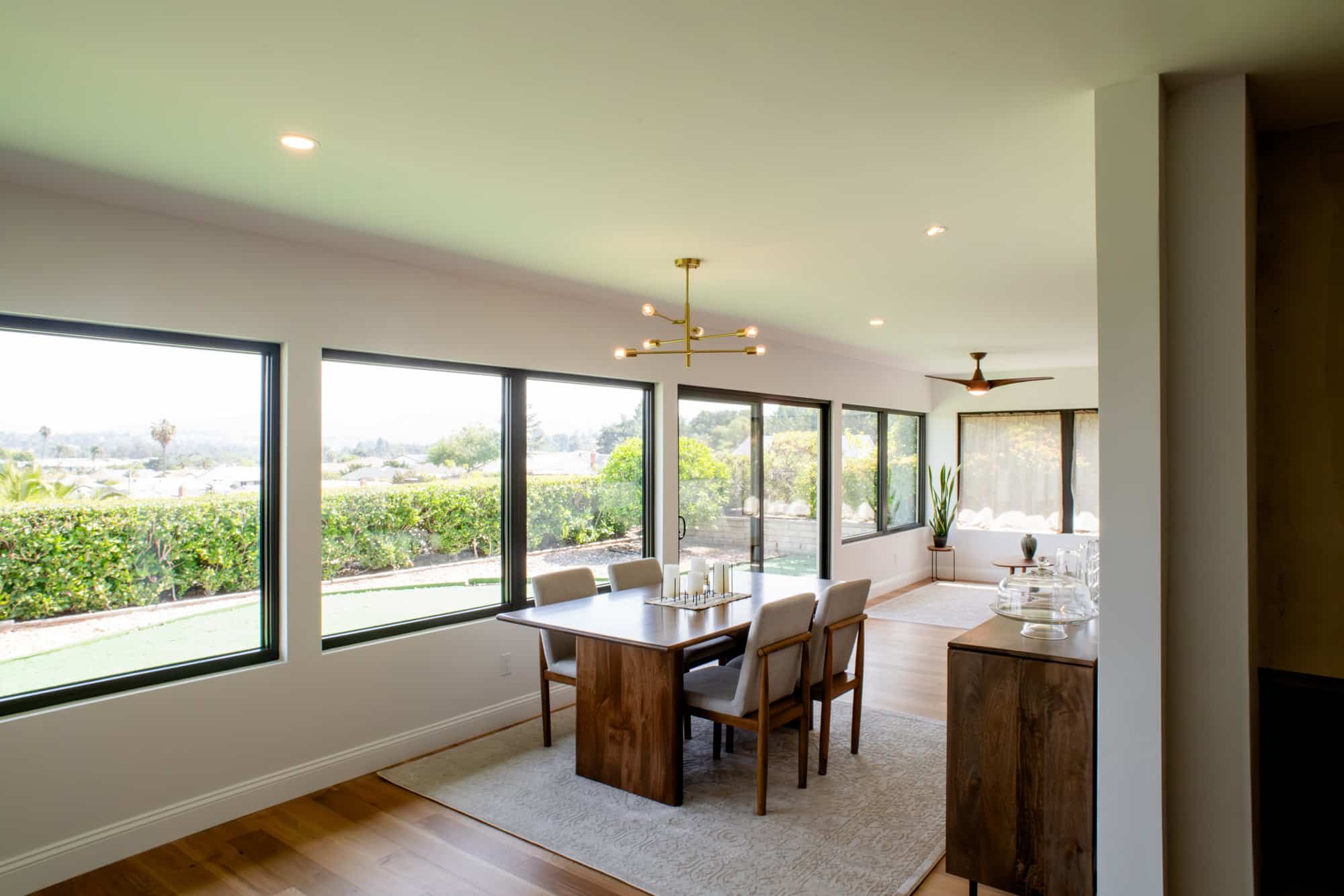 Rancho Bernardo room addition: a dining and living addition with a wall of windows over the yard, white oak floors and a gold chandelier