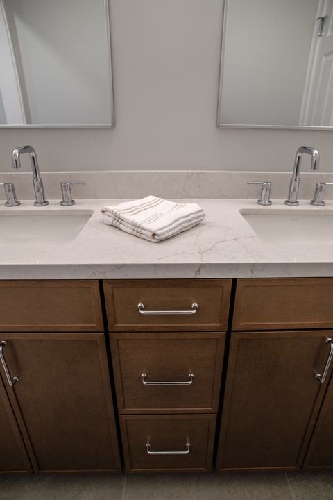 Vanity front with chrome pulls on Maple Latte doors and drawers below the quartz top