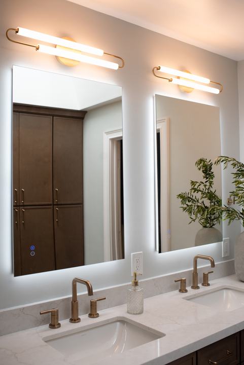 Two brass widespread faucets at undermount sinks on a Calacatta Valentin quartz counter
