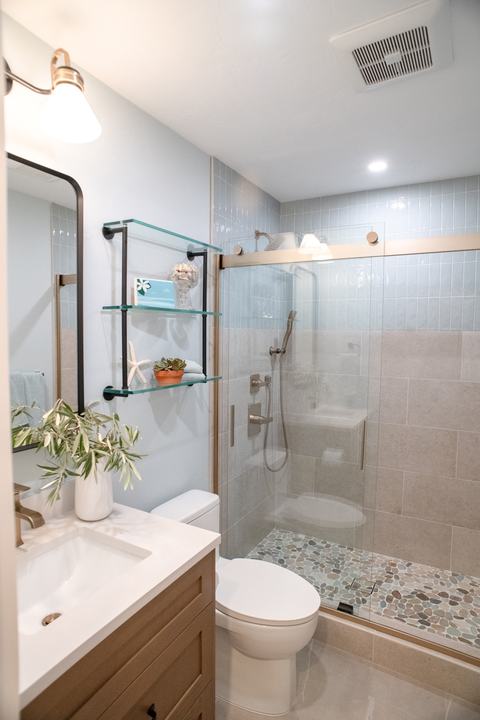 Tall view from the vanity toward the shower, with a recessed light and exhaust fan overhead