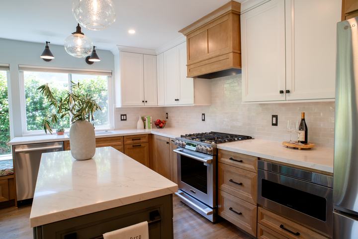 Range wall with the wood hood, gloss backsplash, and microwave drawer beside the refrigerator