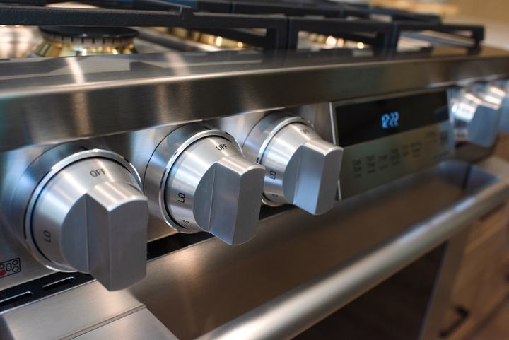 Stainless control knobs along the front of the gas range