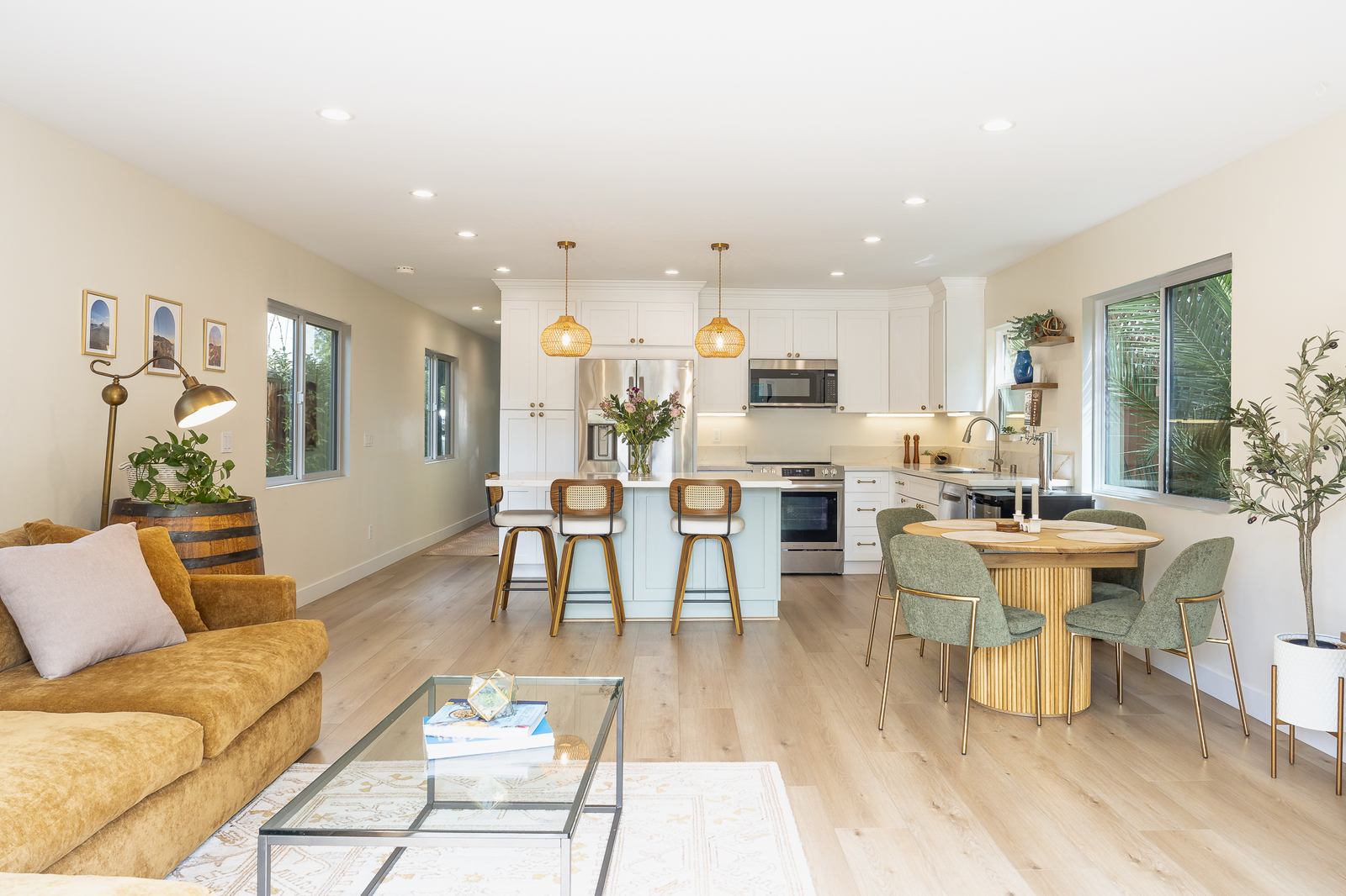 Open kitchen with island seating and a coastal palette in a rebuilt Pacific Beach home