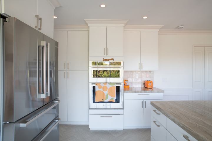 Tall pantry cabinets and wall ovens between the refrigerator and a corner counter