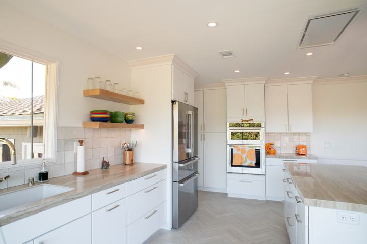 Full kitchen with floating shelves, refrigerator, wall ovens, and a flush ceiling hood above the island