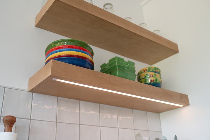 LED strip lighting set into the underside of a maple floating shelf