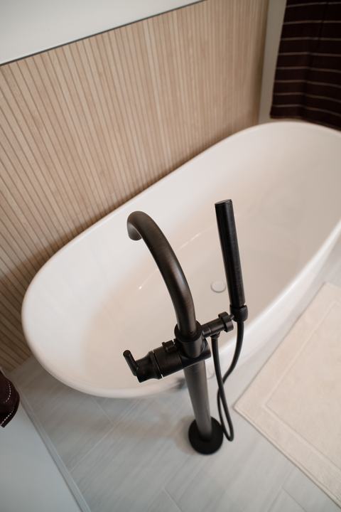 Dark bronze tub filler with handheld sprayer beside the tub