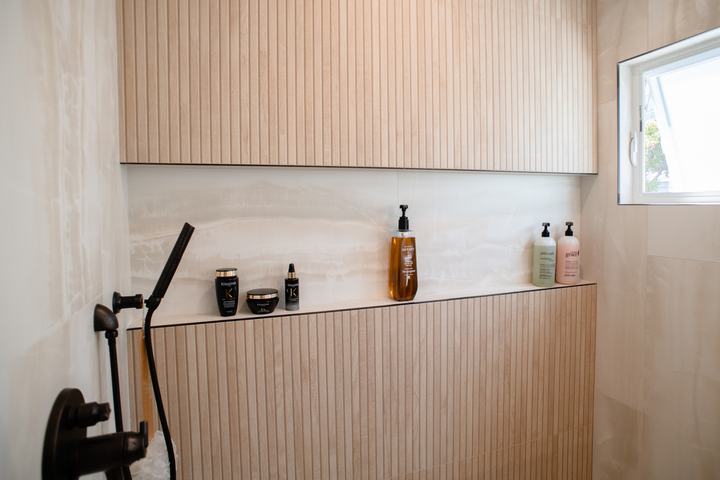 Long shower niche set between maple-look slat porcelain panels