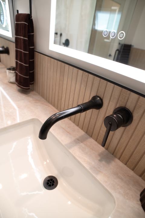 Wall-mounted faucet in dark bronze over an undermount sink