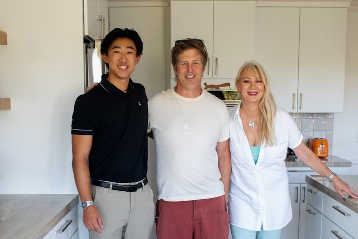 Three people standing together in the finished kitchen