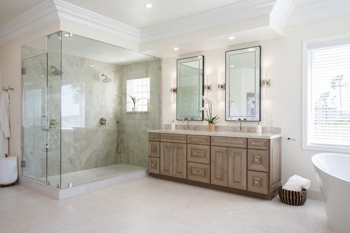 Glass-enclosed Taj Mahal quartzite shower beside maple-almond double vanity in Poway luxury bath remodel