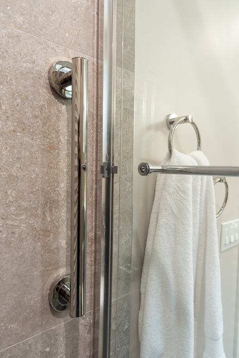 Chrome shower door handle and towel ring detail