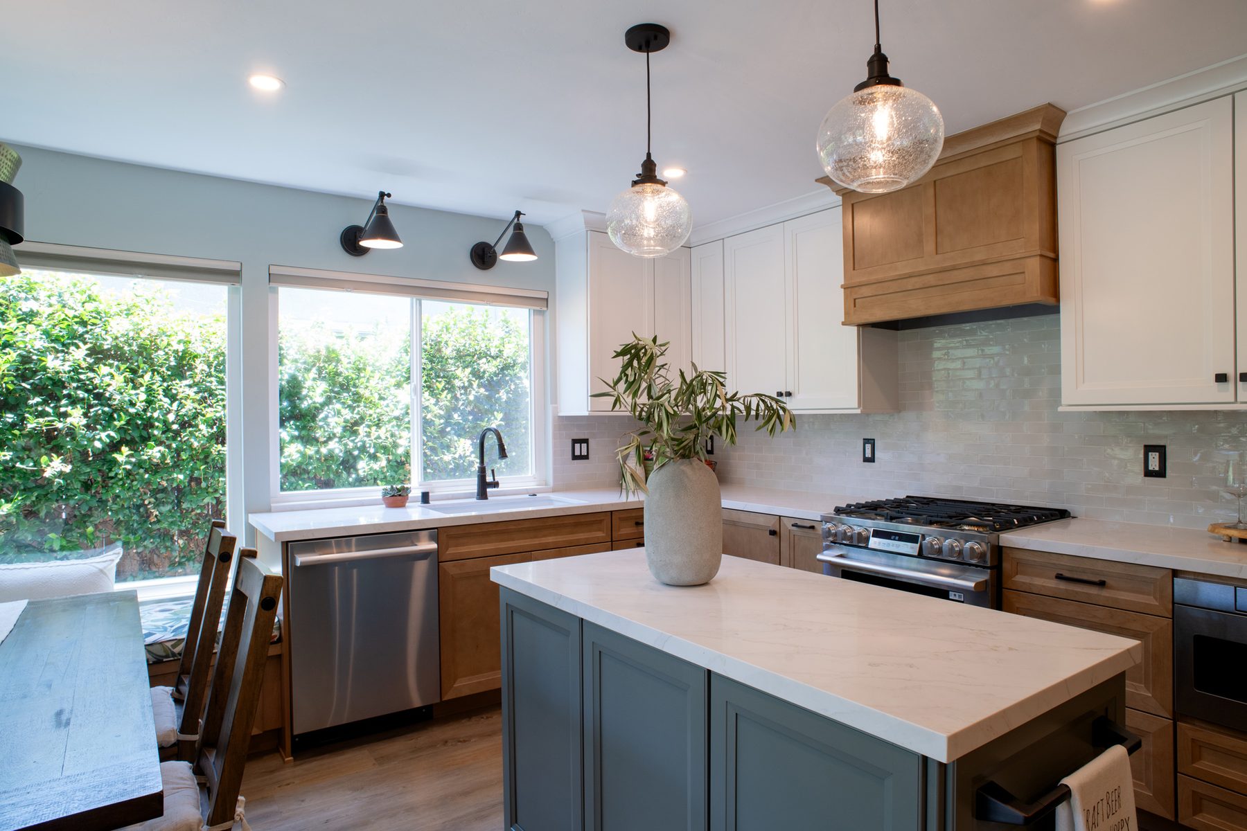 Green kitchen island with maple lower cabinets and white uppers in a Mira Mesa kitchen