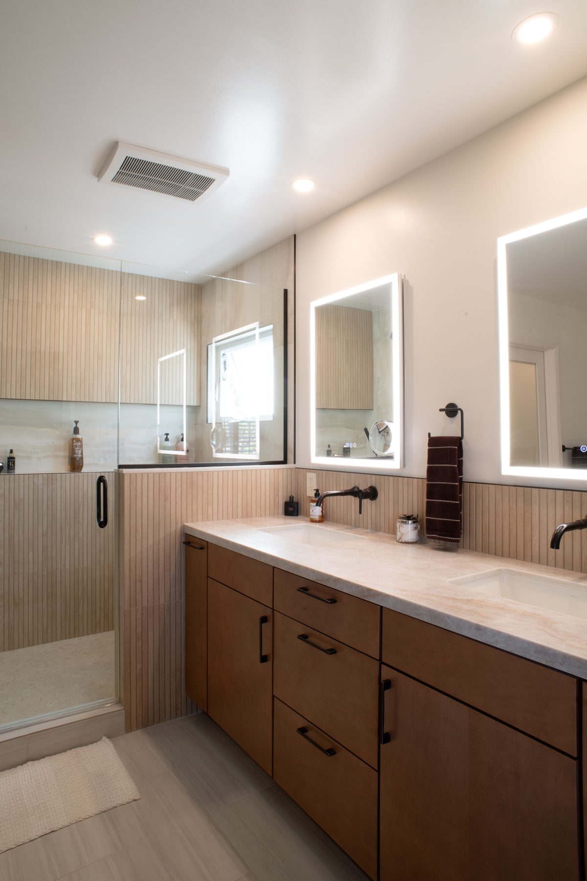 Remodeled Point Loma master bath with a two-sink vanity and walk-in shower