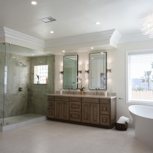 Wide room view showing quartzite slab shower, double vanity, freestanding tub and chandelier