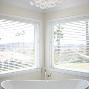 Sculptural bubble-glass chandelier sparkling above the soaking tub with panoramic hillside views.