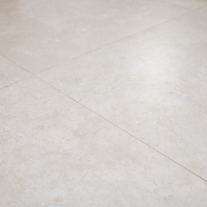 Warm limestone-look porcelain floor tiles in a large-format grid with tight grout joints.