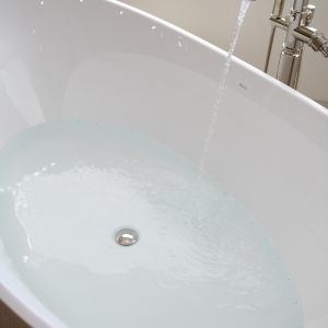 Freestanding tub filling with heated micro-bubble water therapy for a spa-like soak.