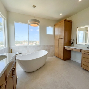 Full room view of tub, vanity, makeup area, and panoramic windows.