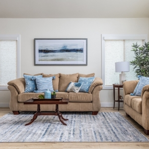Bright living room with tan sofas, blue pillows
