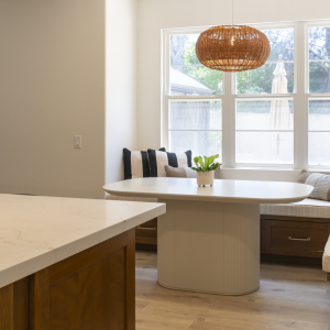 View from island to banquette and patio door, highlighting quartz surface and seamless indoor-outdoor flow