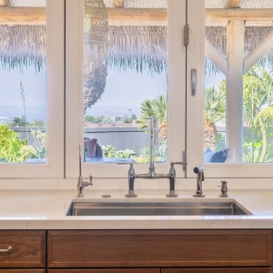 Enlarged kitchen window over Rohl undermount sink with Kohler Edalyn bridge faucet and quartz counters