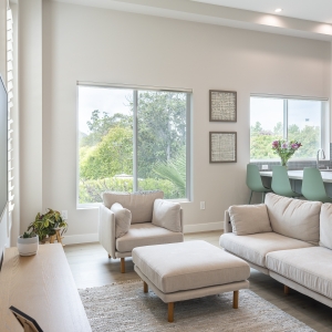 Neutral sofa set facing TV between tall shutters