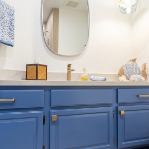 Oval mirror with coastal glass pendant above the vanity