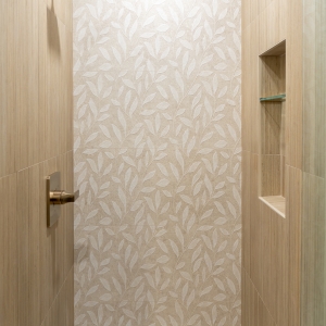 Leaf-pattern Wynwood feature wall with brass shower trim and built-in niche