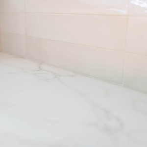 Calacatta-style countertop and glossy porcelain backsplash detail