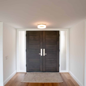 Closed dark wood double entry doors with sidelights and white oak flooring