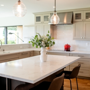 Large kitchen island with pendant lights and oatmeal cabinets