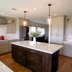 Knotty alder kitchen island with oatmeal perimeter cabinets and white backsplash