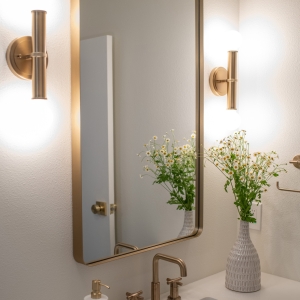 Hall bathroom vanity with brass faucet and mirror