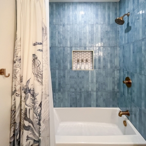 Hall bathroom tub and shower with blue wall tile