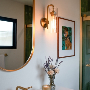 Primary bathroom sconce, mirror, and artwork detail