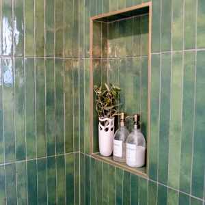 Primary bathroom shower niche with green tile